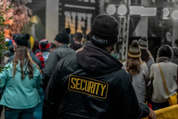 A security personal standing in front of a yellow railing